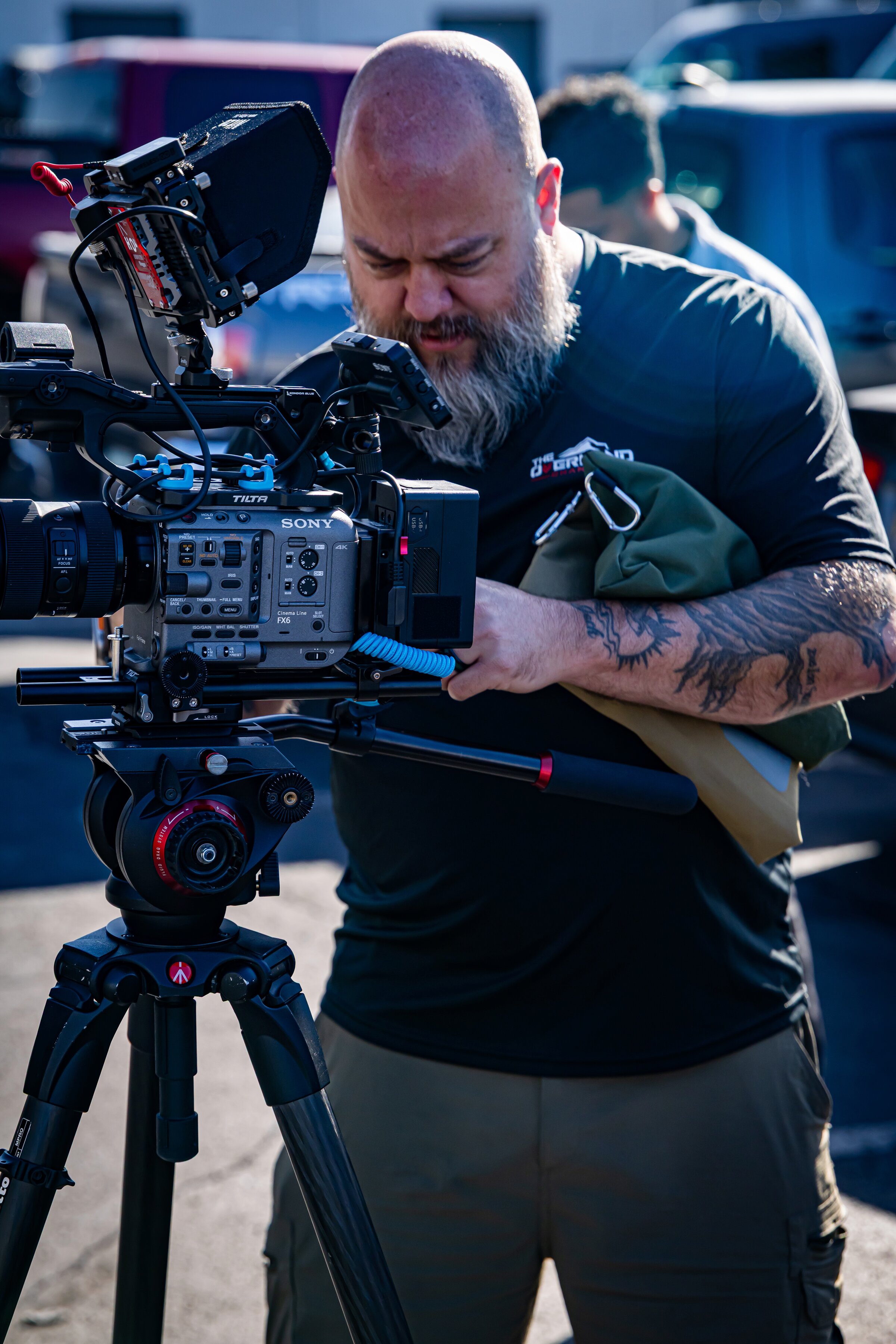 A filmmaker adjusts a cinema camera and monitor before a shoot.